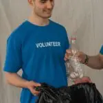Team of cheerful young volunteers sorting plastic waste for environmental conservation.